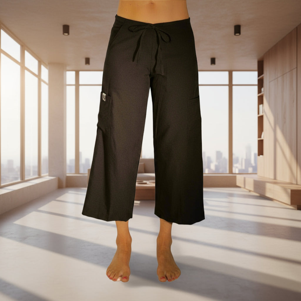 Person wearing black wide-leg pants on a plain background